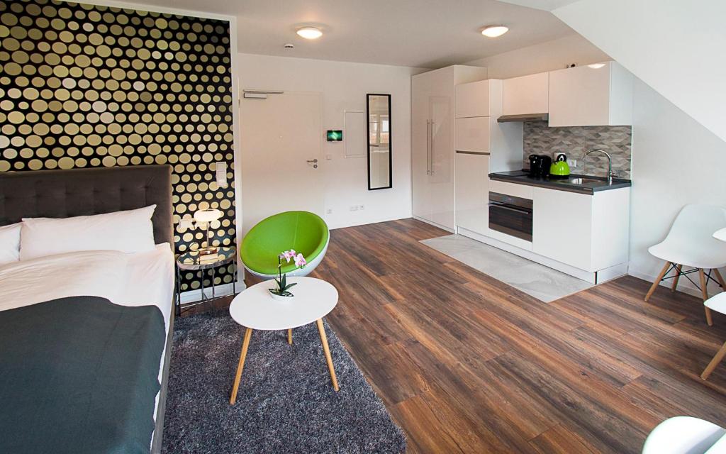 a living room with a bed and a kitchen at Eco Smart Apartments Nürnberg Süd in Nürnberg