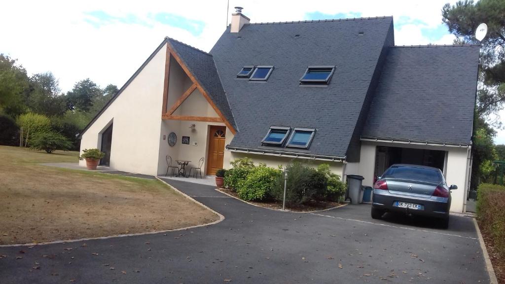 una casa con un coche aparcado en la entrada en chambre chez l habitant, en Malguénac