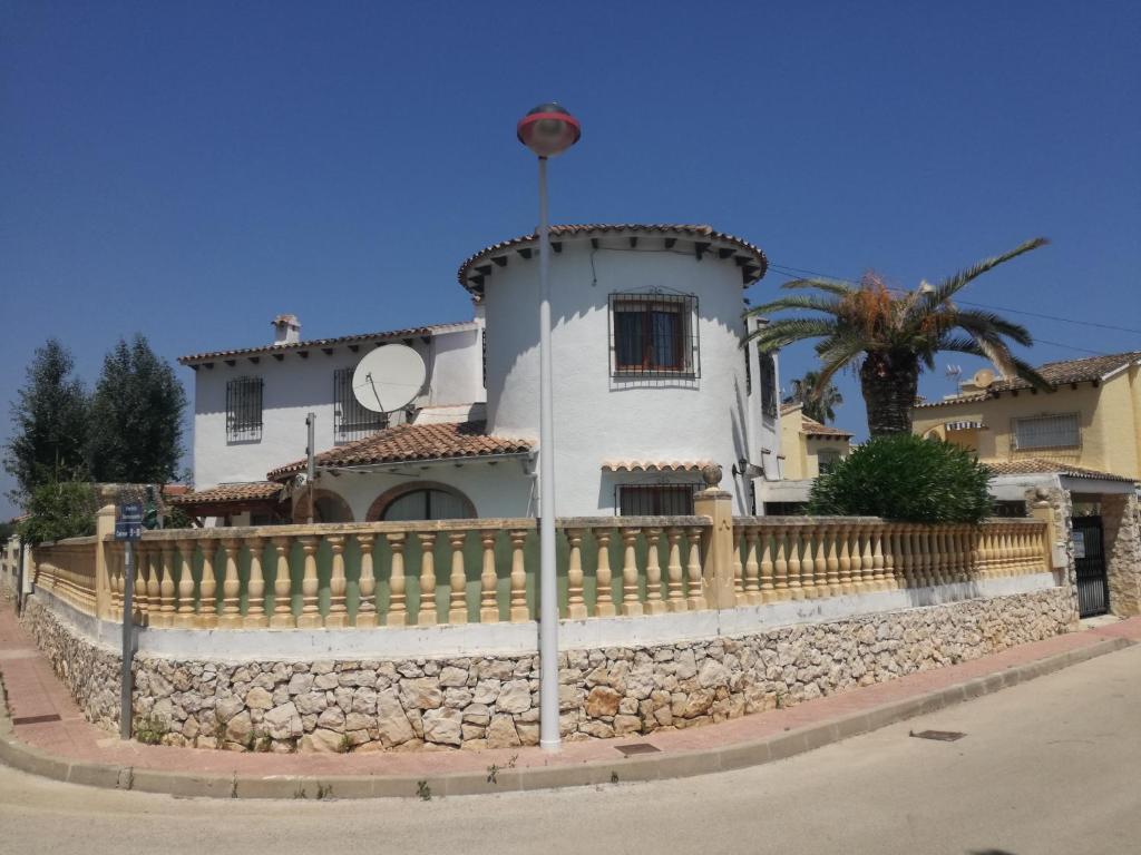 een wit huis met een hek ervoor bij Estudios privados en Villa con piscina privada in Els Poblets