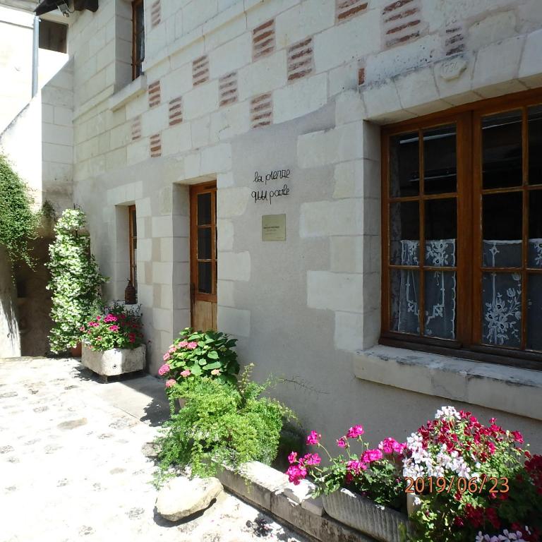 um edifício com flores em frente em La Pierre qui Parle em Luynes