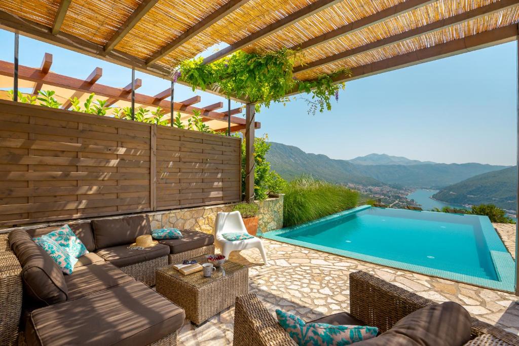 un patio con piscina y una casa junto a la piscina en Villa Turcoisinus HH, en Mokošica