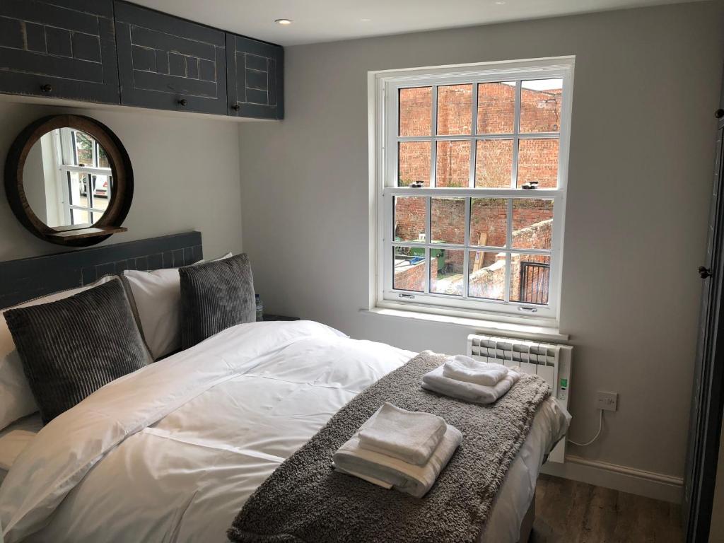um quarto com uma cama com duas toalhas em The Lodgings em Beverley