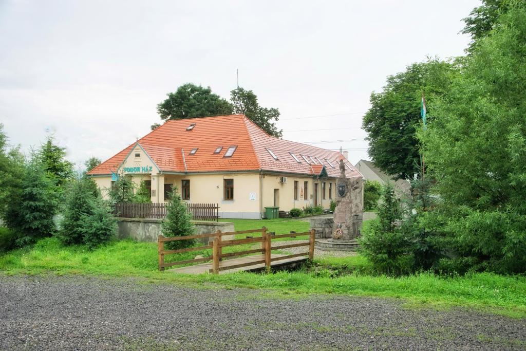 ein Haus mit einem orangenen Dach und einem Holzzaun in der Unterkunft Fodor Ház in Miercurea Ciuc