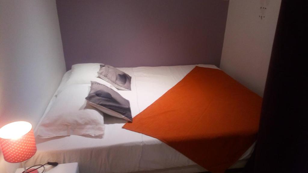 - une chambre dotée d'un lit blanc avec un objet orange dans l'établissement Appartement 50m2, à Agde