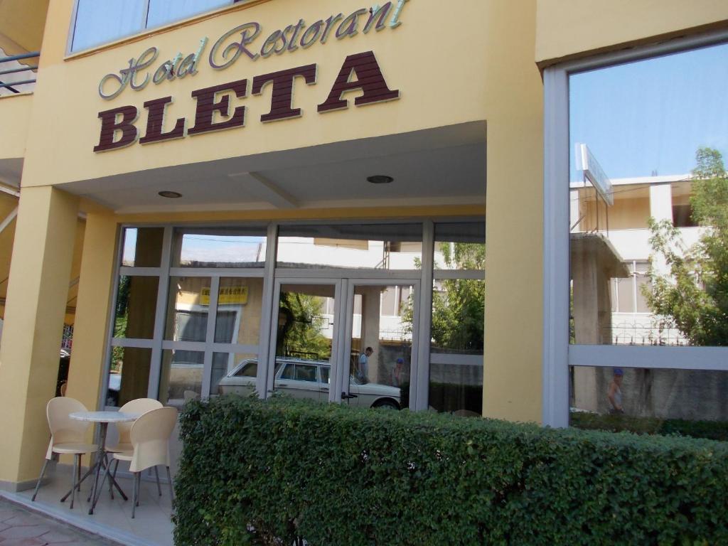 un restaurante con mesa y sillas frente a un edificio en Hotel Bleta, en Gjirokastra