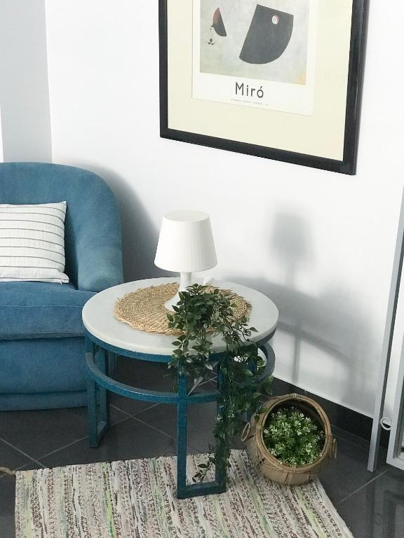 a living room with a blue couch and a table with a lamp at ROOMQUEO-Only Adults in Barbate