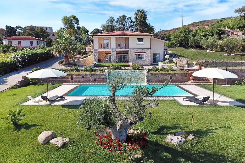 a house with a swimming pool in a yard at Villa Turquoise in Magomadas