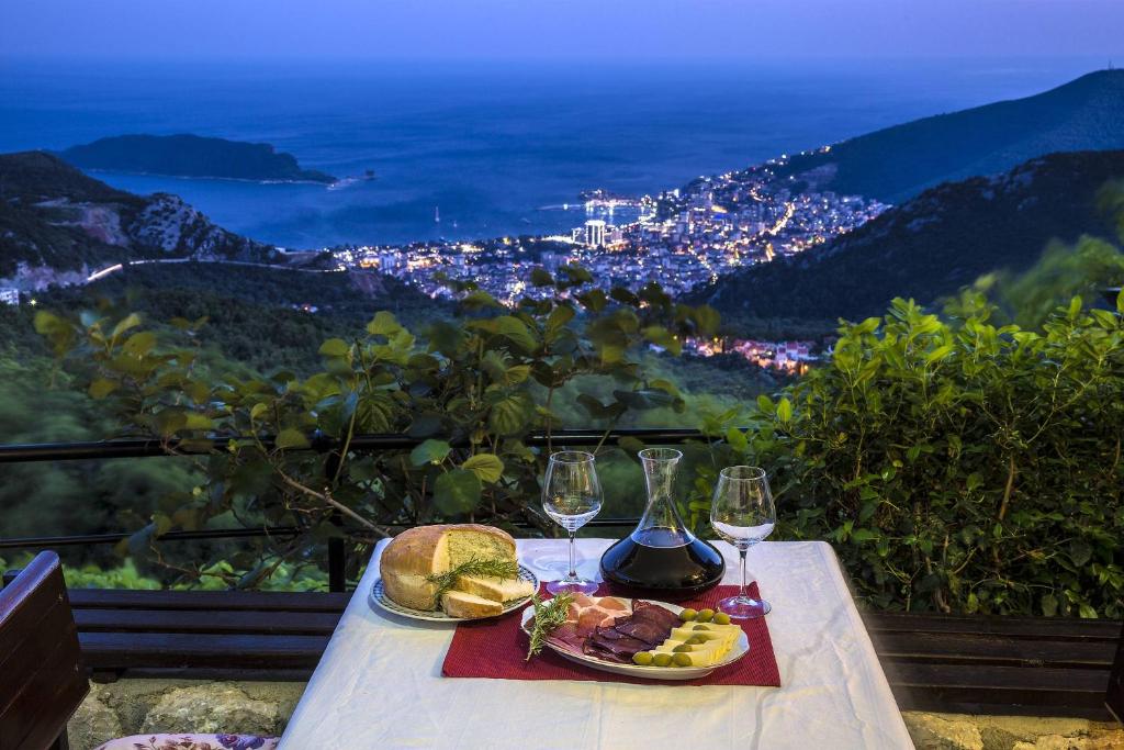 a table with two plates of food and wine glasses at Villa Nera in Budva