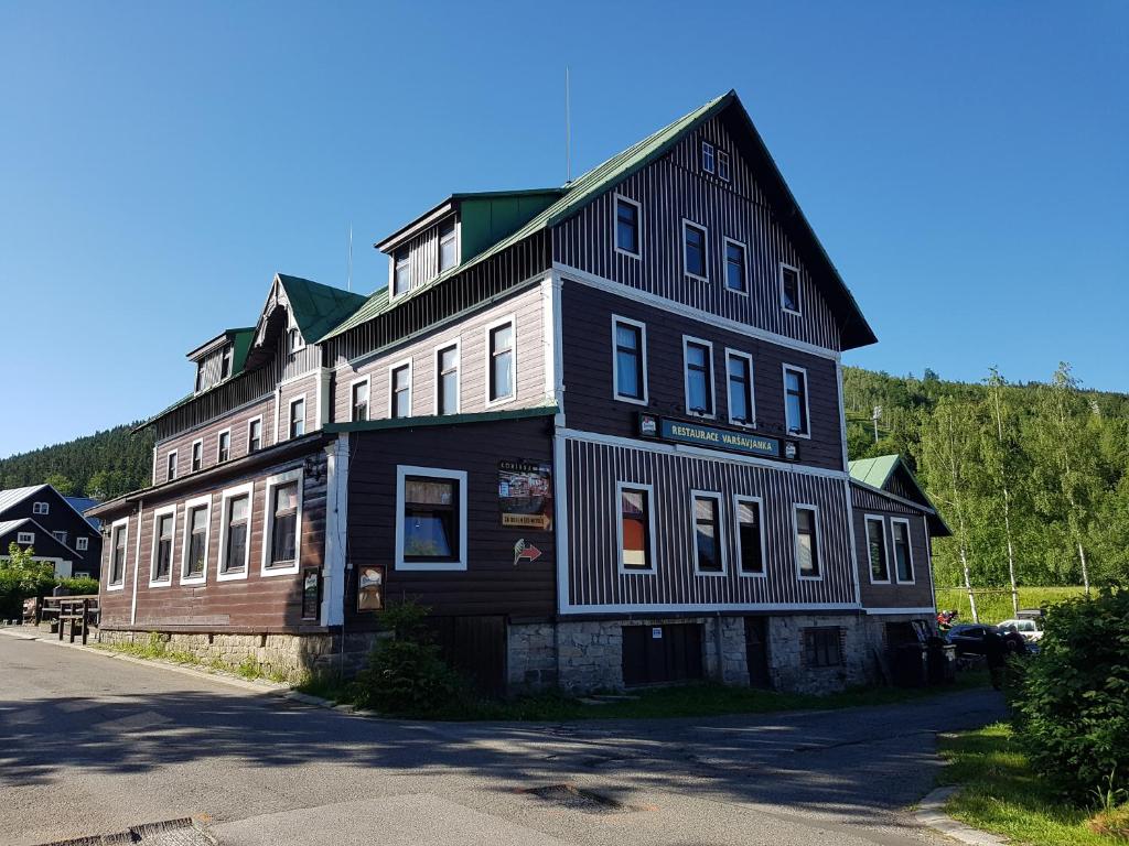 a large black and white building on the side of a street at Penzion Varšavjanka in Harrachov