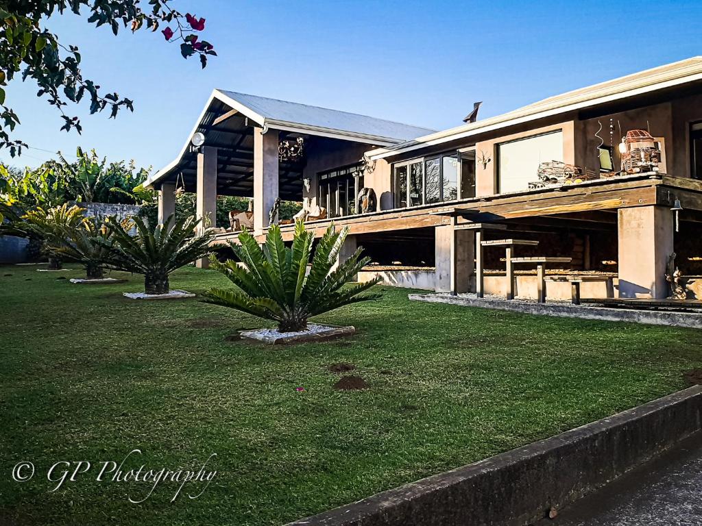 una casa con dos palmeras delante de ella en Laguna Lodge, en Graskop