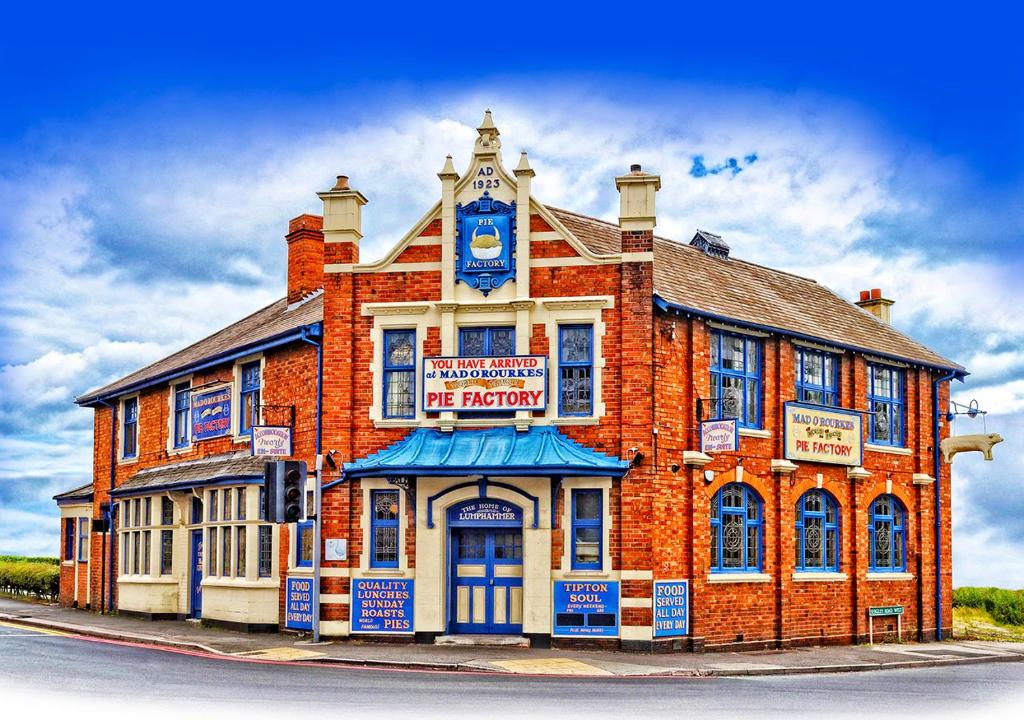 a red brick building with a clock on it at Mad O'Rourkes Pie Factory in Dudley