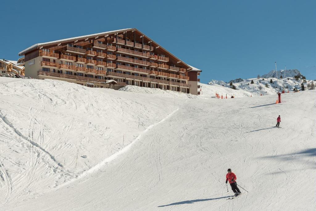 duas pessoas a esquiar num alojamento coberto de neve em Residence Le Mont Soleil - maeva Home em Plagne Villages