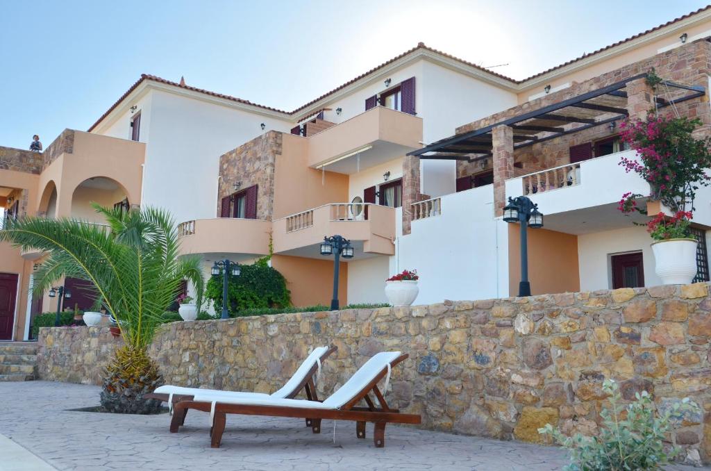 two benches in front of a building at Anais Apartments in Chios