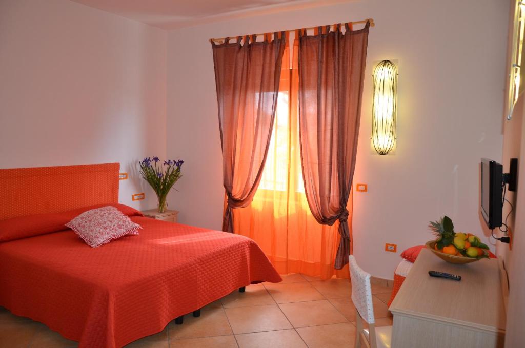 una camera da letto con un letto rosso e una finestra di Pinguino B&B a Scala