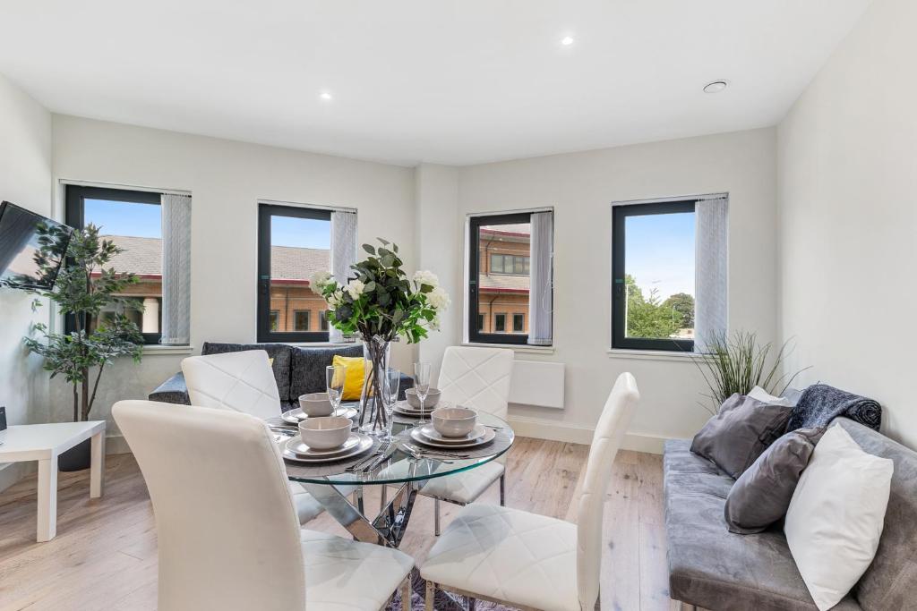 a living room with a table and a couch at Mondial Apartments at Heathrow in Harmondsworth