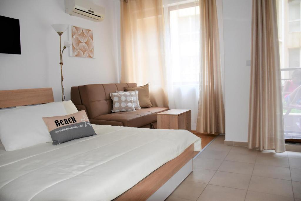 pokój hotelowy z łóżkiem i kanapą w obiekcie Aglaya 2 w mieście Pomorie