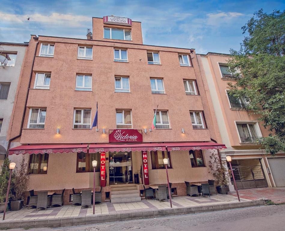 a large brick building on a city street at Victoria Hotel in Varna City