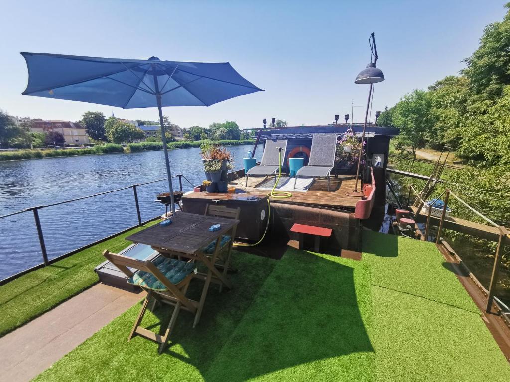 ein kleines Boot mit einem Tisch und einem Sonnenschirm in der Unterkunft Le grand large in Metz