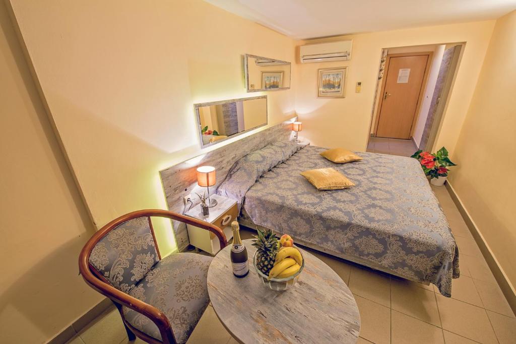 ein kleines Schlafzimmer mit einem Bett und einem Tisch mit Bananen darauf in der Unterkunft Victoria Hotel in Warna