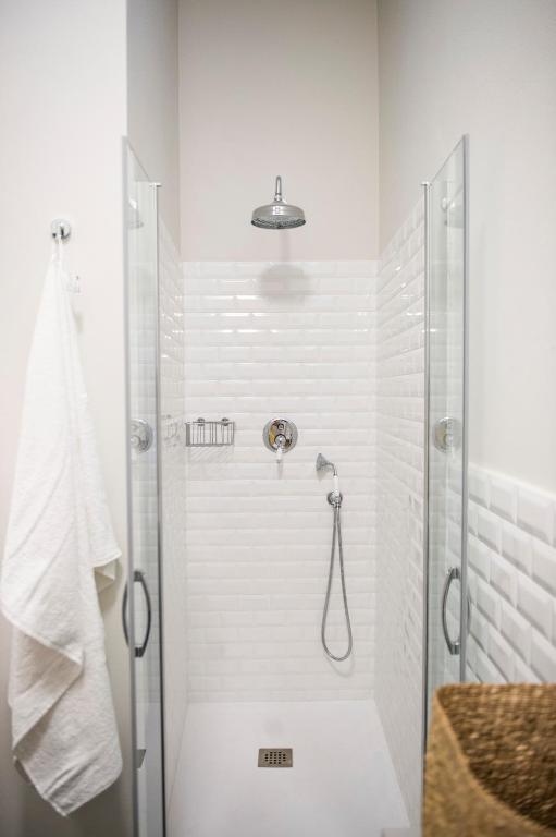 W białej łazience z przeszklonymi drzwiami znajduje się prysznic. w obiekcie Gualchierina apartment w mieście Prato