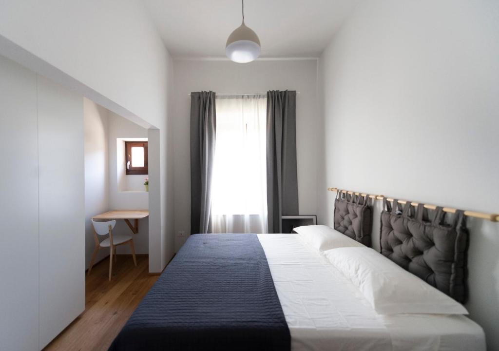 sypialnia z łóżkiem z czarnym zagłówkiem i oknem w obiekcie Gualchierina apartment w mieście Prato