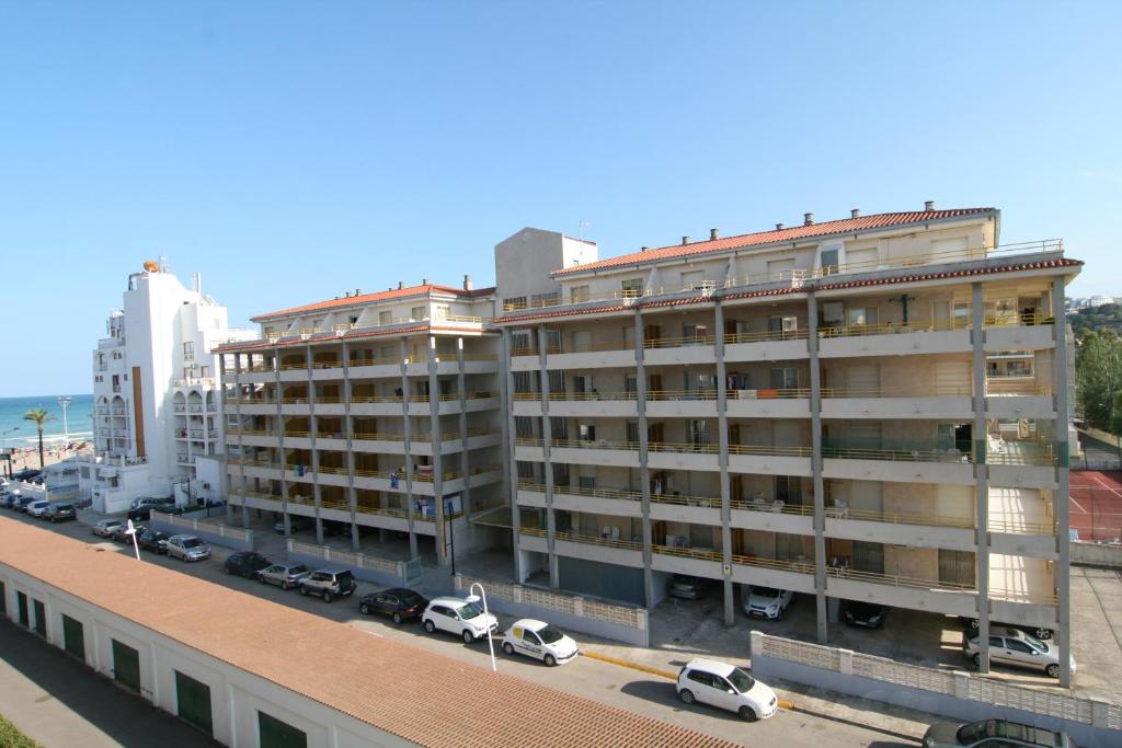 a large building with cars parked in a parking lot at Edificio Esmeralda in Peniscola