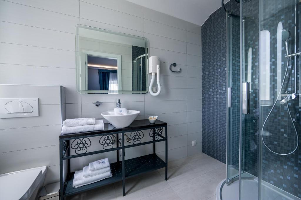 a bathroom with a sink and a shower at Hotel Domino in Opatija