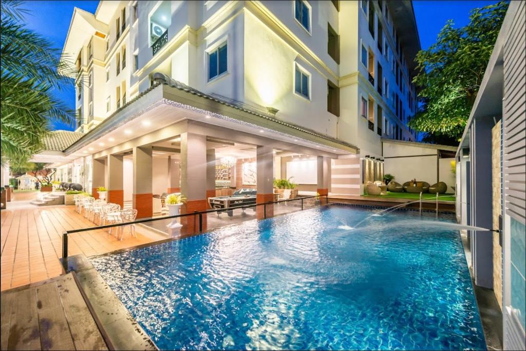 a swimming pool in front of a building at Patra Luxury Hotel Suvarnabhumi in Ban Khlong Bang Krathiam