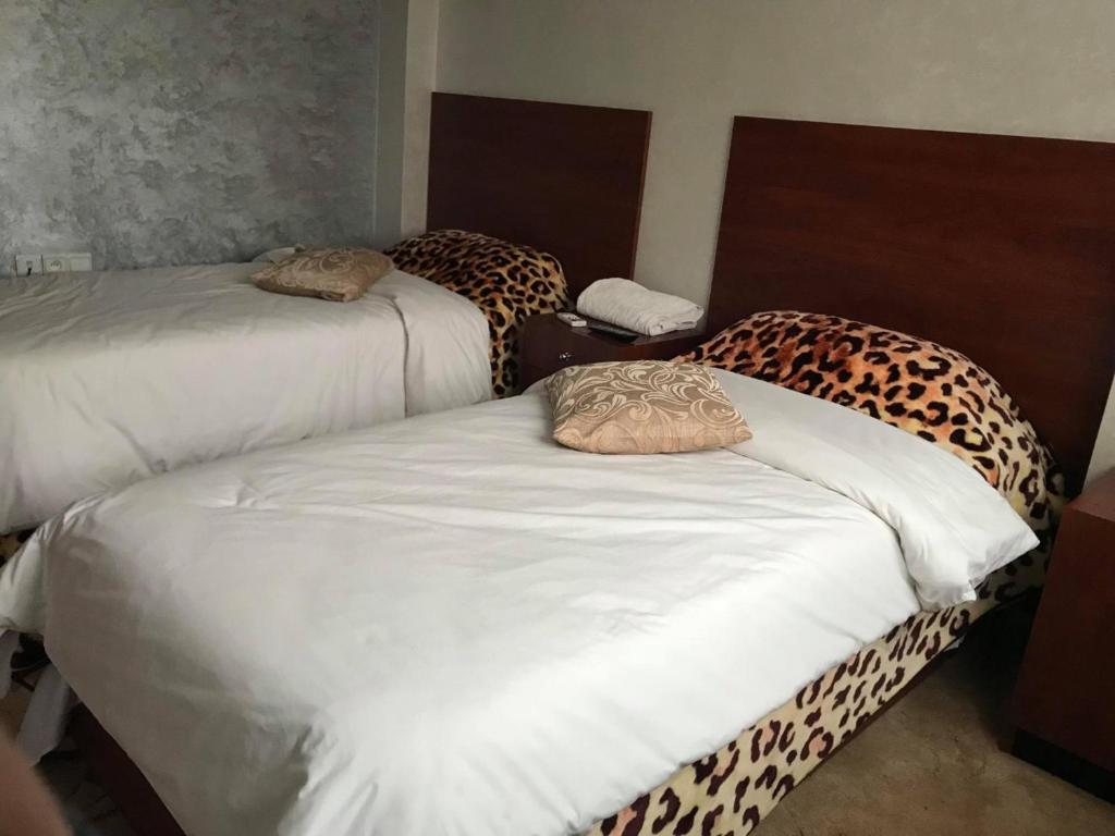 a room with two beds with leopard print at HOTEL BORJ EL ARAB in Khouribga