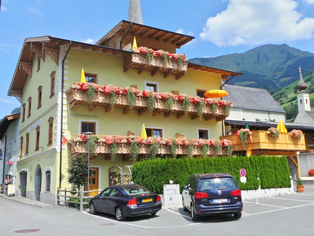 two cars parked in a parking lot in front of a building at Haus Groder in Rauris