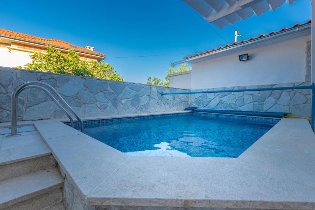 una piscina frente a una casa en Apartments Lapis en Jadranovo