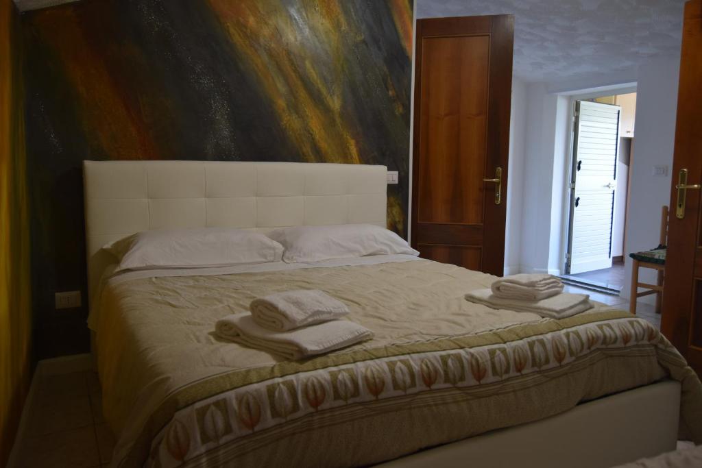 - une chambre avec un grand lit et des serviettes dans l'établissement B&B La terrazza, à Montalbano Elicona