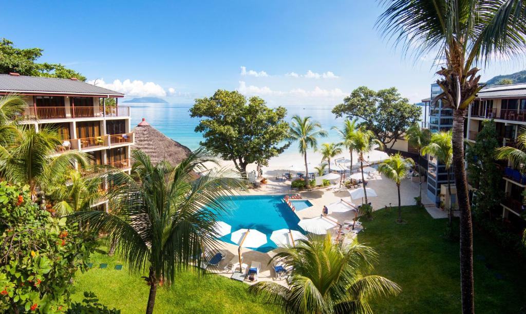 a beach with palm trees and palm trees at Coral Strand Smart Choice in Beau Vallon