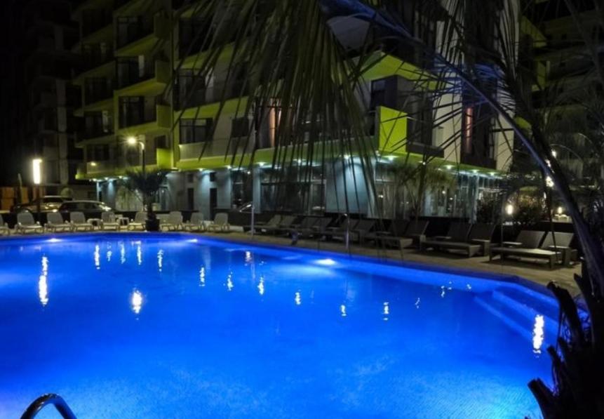 a large blue swimming pool in front of a building at V&T Residence Mamaia Nord in Mamaia Sat/Năvodari