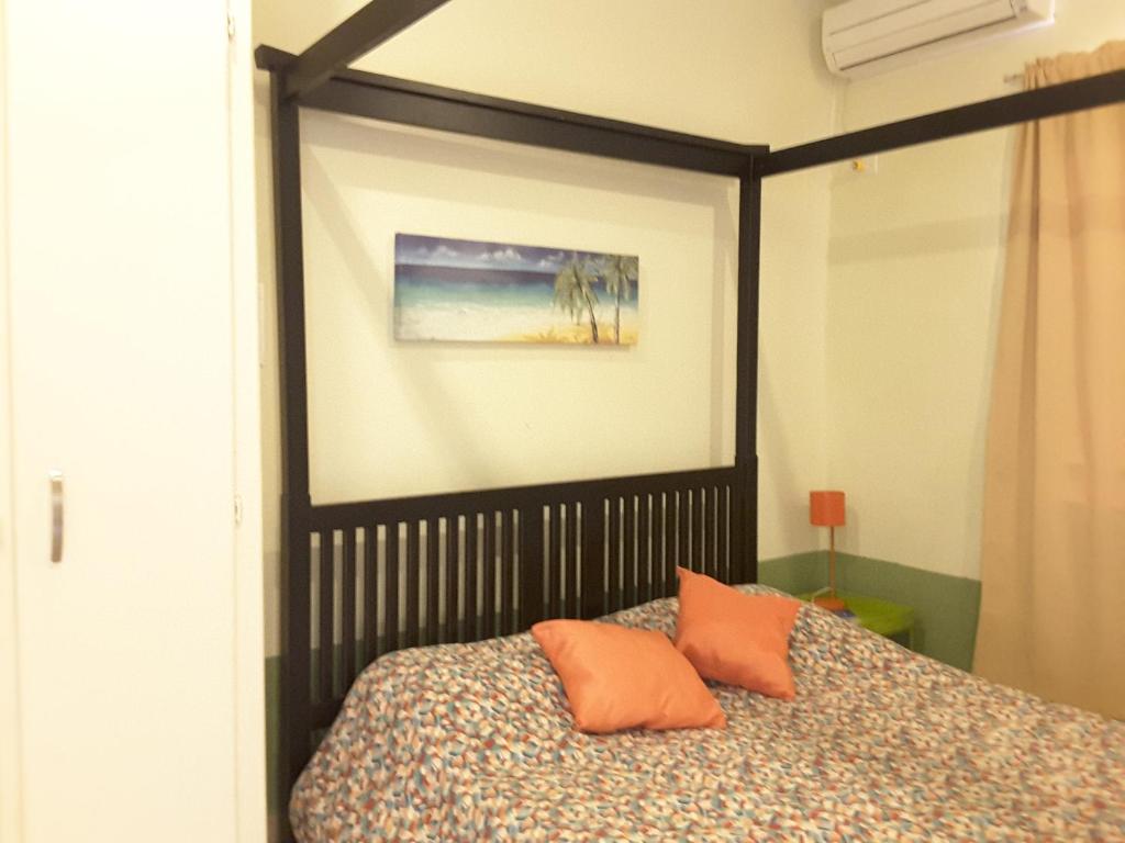 a bedroom with a bed with orange pillows on it at SXM Spotters Paradise in Lowlands