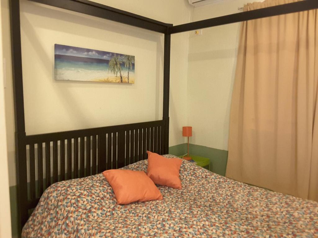a bedroom with a bed with two orange pillows at SXM Spotters Paradise in Lowlands