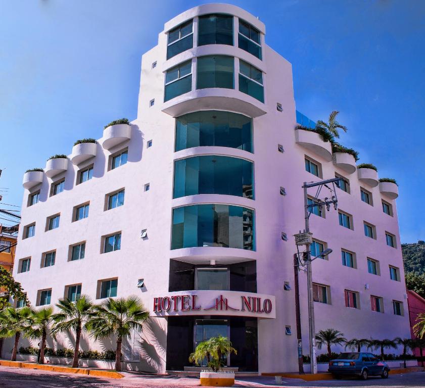 a white building with a hotel miu sign on it at Hotel Nilo in Acapulco