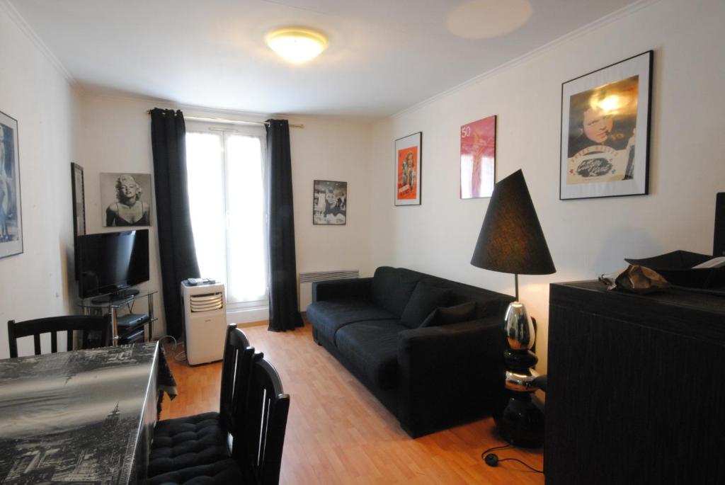 un salon avec un canapé noir et une télévision dans l'établissement Les Serbes 2P RET29, à Cannes