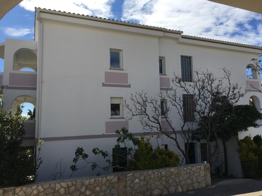 a white building with a fence in front of it at Apartments MiaMaja in Novalja