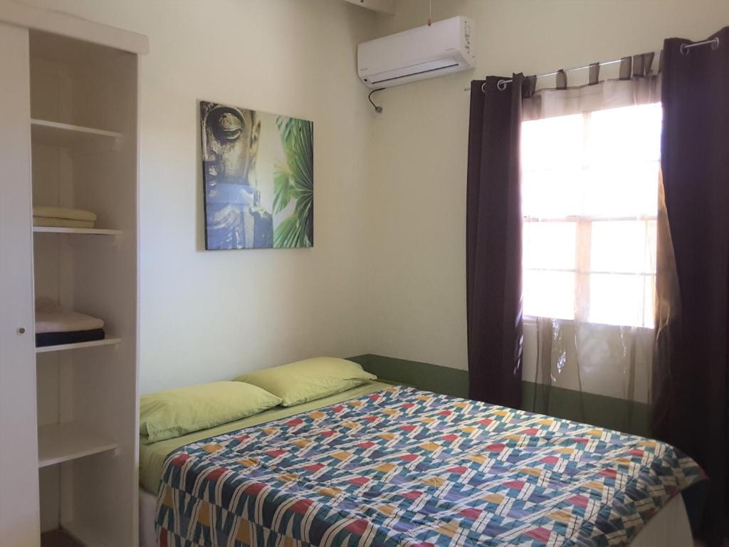 a small bedroom with a bed and a window at SXM Spotters Paradise in Lowlands