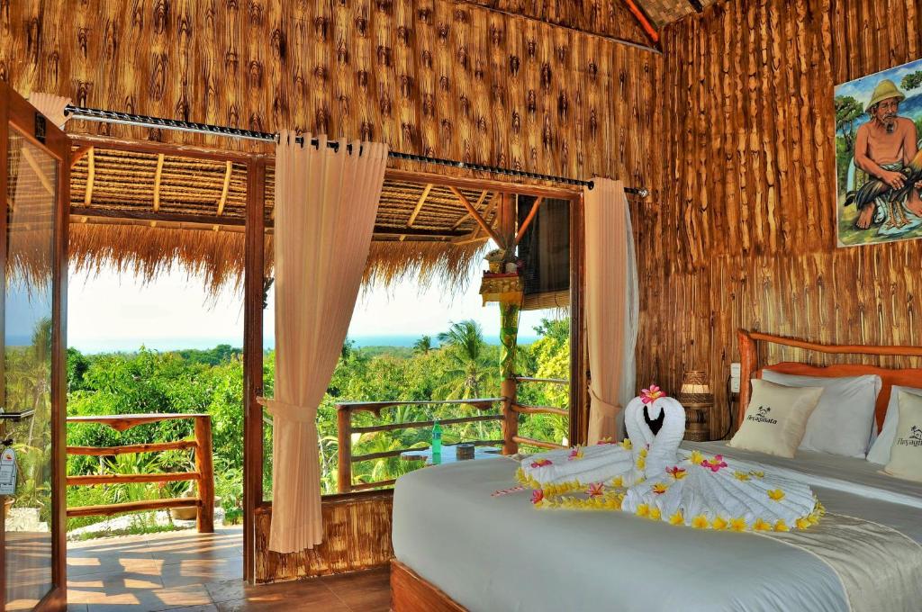 a bedroom with two beds in a room with a window at Aryaginata Cliff Cottages in Nusa Penida