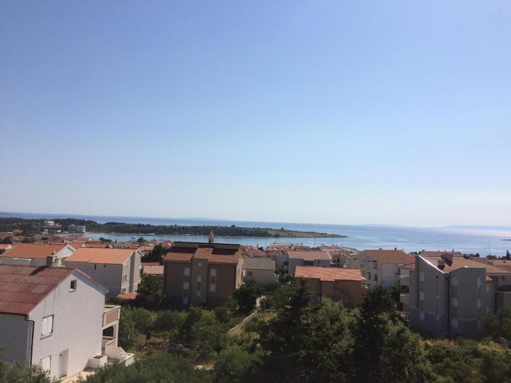 a city with buildings and the ocean in the background at Apartments MiaMaja in Novalja