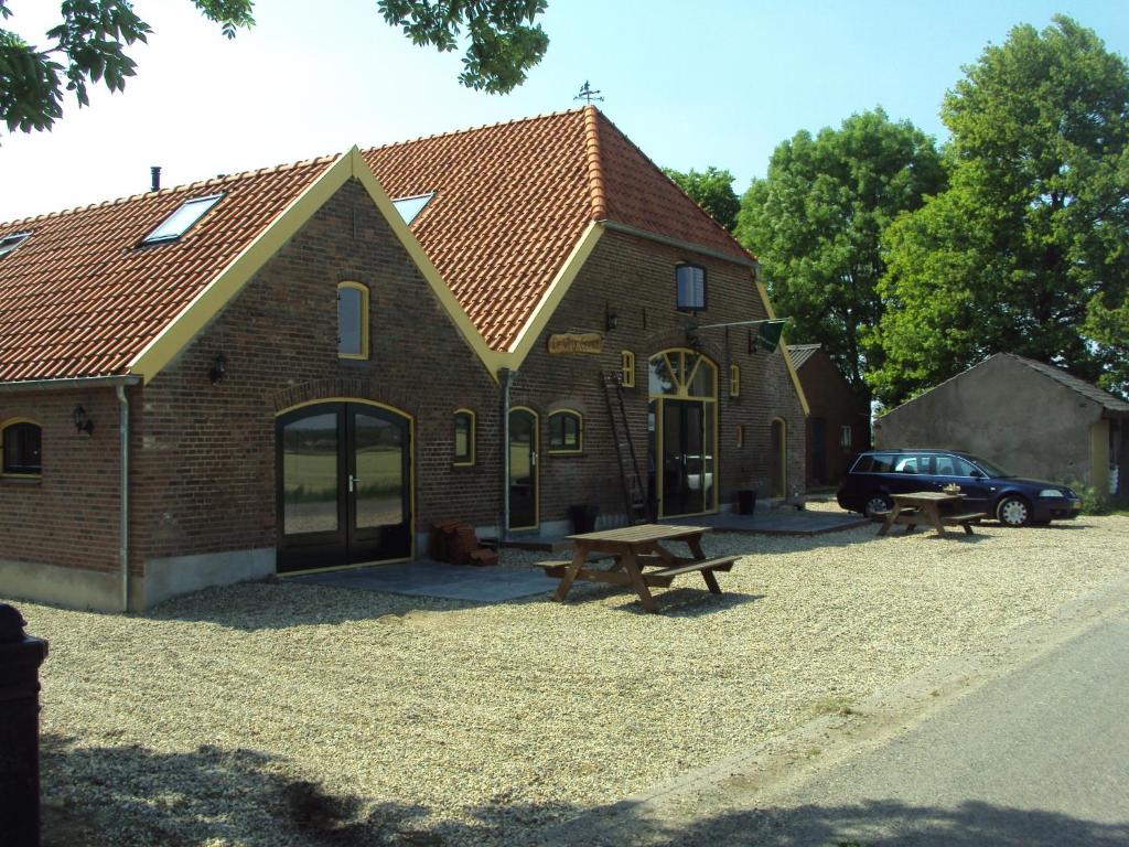 um edifício com uma mesa de piquenique em frente em Boerderij De Vrije Geest em Toldijk