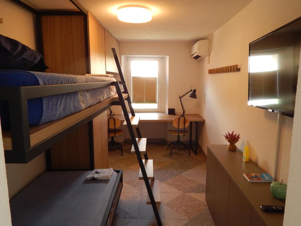 Kleines Zimmer mit einem Etagenbett und einem Schreibtisch. in der Unterkunft Casa Riccobon in Koper