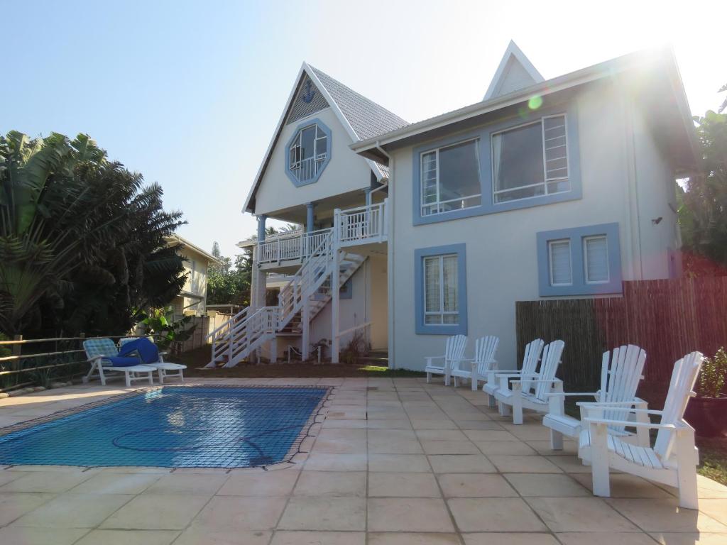 謝普斯敦港的住宿－Dolphin Place，一座带白色椅子和游泳池的房子