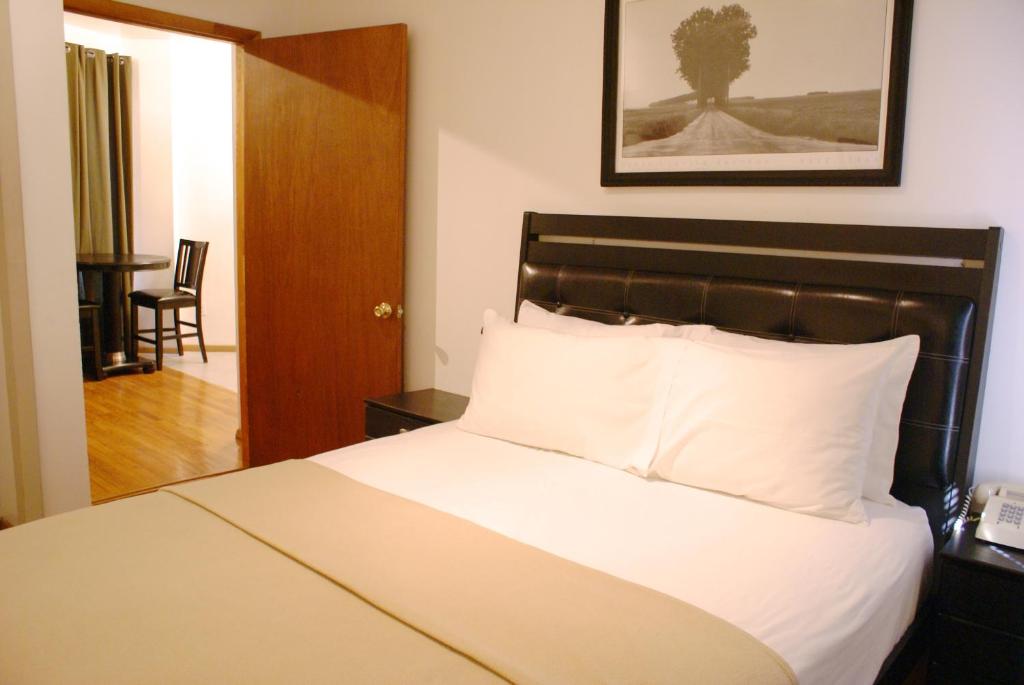 a hotel room with a bed with white sheets at Off SoHo Suites Hotel in New York