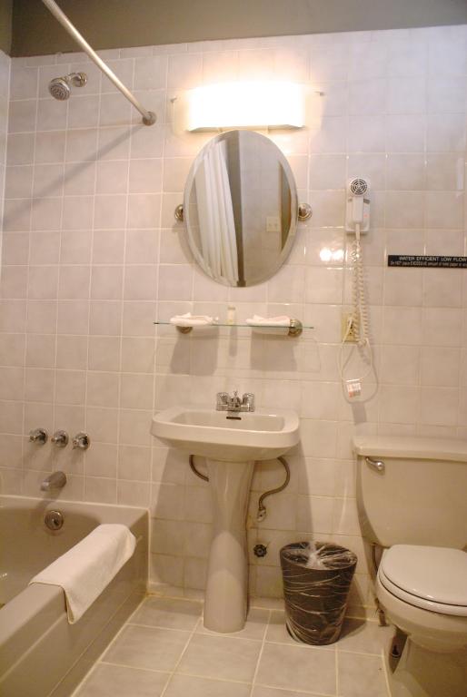 ein Badezimmer mit Waschbecken, Toilette und Spiegel in der Unterkunft Off SoHo Suites Hotel in New York