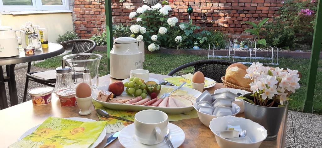 a table with a plate of food and eggs and fruit at Pension Bartoschewitz in Lenzen