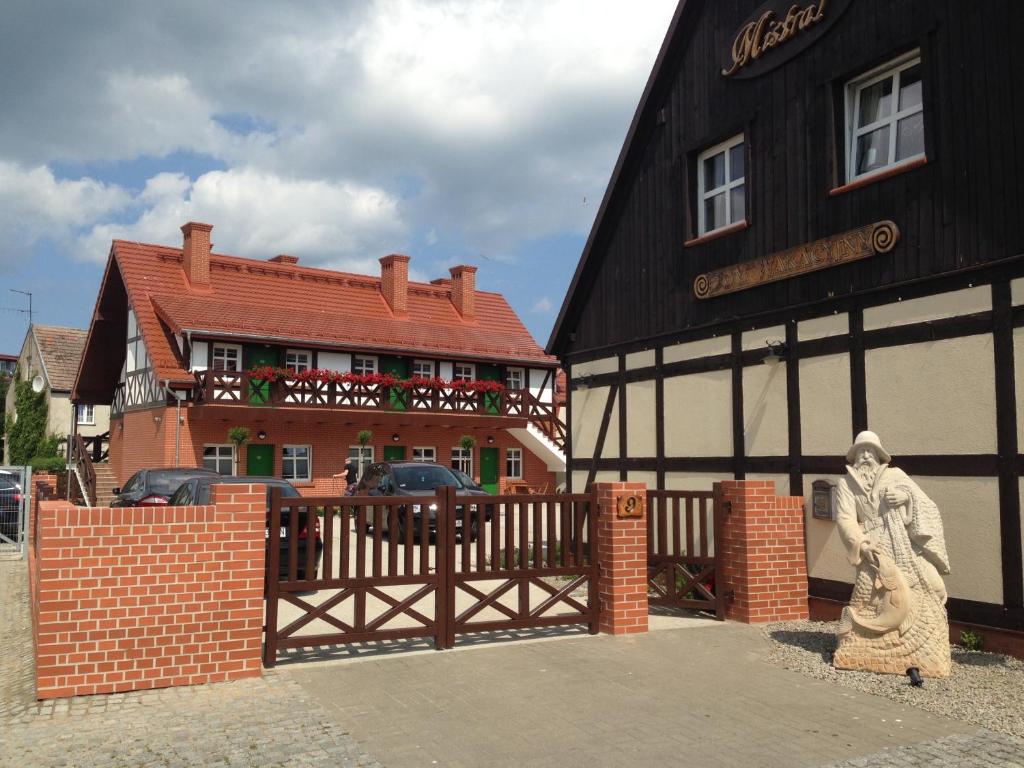 a woman standing in front of a building with a gate at Mistral Ustka in Ustka