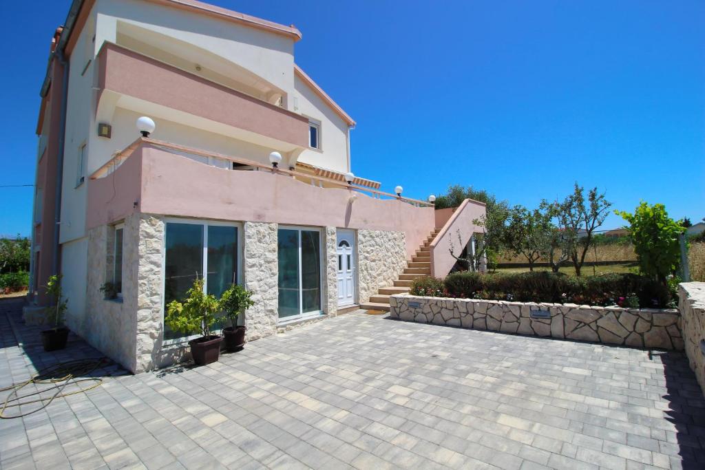 a villa with a driveway in front of a house at Apartments Anka with Seaview in Vrsi